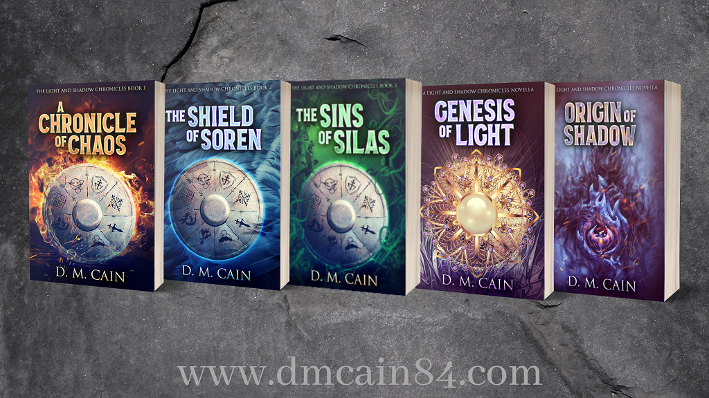 All of the books in the Light and Shadow Chronicles together. Shield designs feature fire for A Chronicle of Chaos, feathers for The Shield of Soren, leaves and vines for The Sins of Silas, a golden necklace or genesis of Light and purple smoke for Origin of Shadow